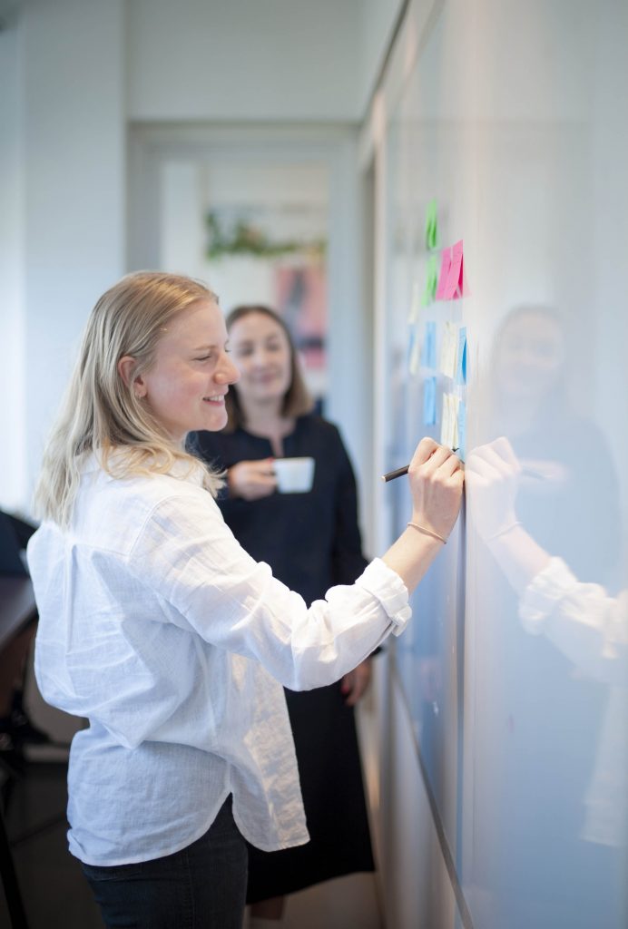 Ingeborg skriver på tavle mens Hanna ser på